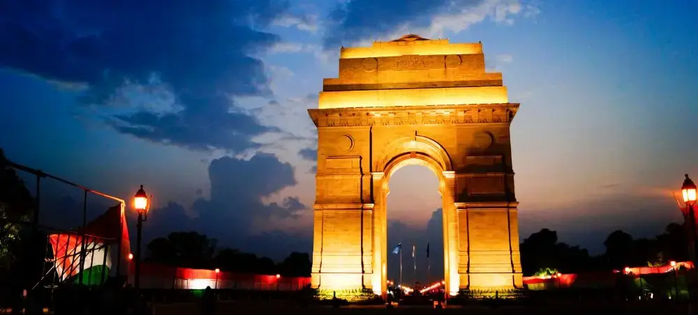 India Gate monument illuminated at dusk in New Delhi, showcasing the capital's iconic architecture