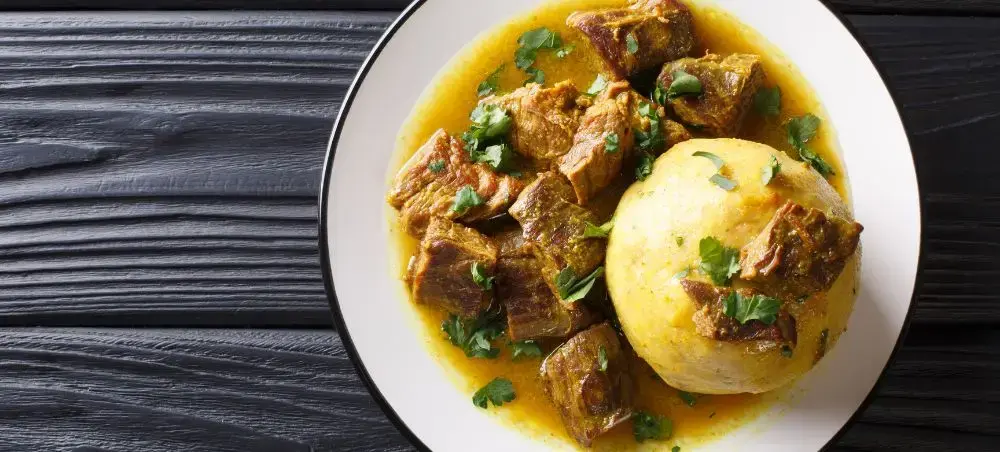 Traditional Dominican pollo guisado with tender chicken, potatoes and cilantro in rich saffron broth