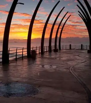 Durban's iconic beachfront promenade at golden hour with sculptural arches framing the Indian Ocean coastline