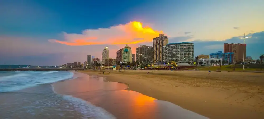 Durban beachfront skyline at sunset with golden sand beach and modern hotels along South Africa's coast