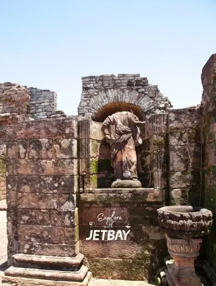 Ancient stone ruins with classical statue in archway showcase Encarnacion's historic attractions for luxury travelers