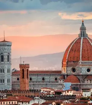 Florence Cathedral's iconic Renaissance dome dominates the historic cityscape at sunset in Italy