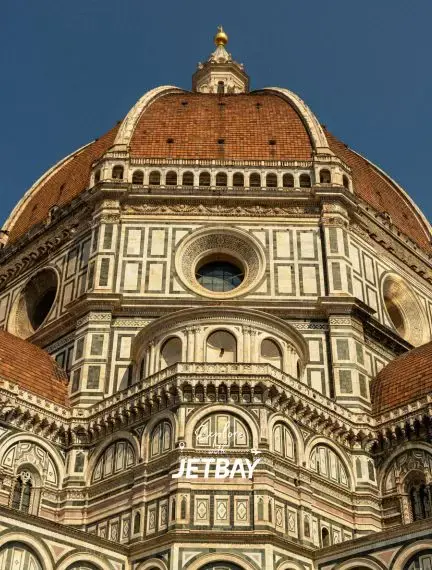 Florence Cathedral's iconic Renaissance dome with intricate marble facade and terracotta tiles against blue sky