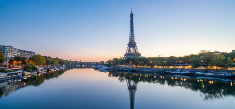 Eiffel Tower reflecting in Seine River at sunset showcasing Paris as premier luxury travel destination