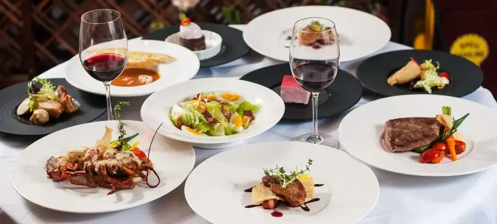 Gourmet French cuisine featuring lobster, steak, and fine wine showcasing luxury dining experiences in France