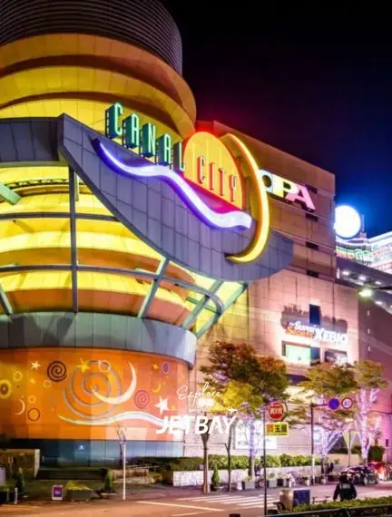 Canal City Hakata shopping complex illuminated at night in Fukuoka, showcasing vibrant neon signage