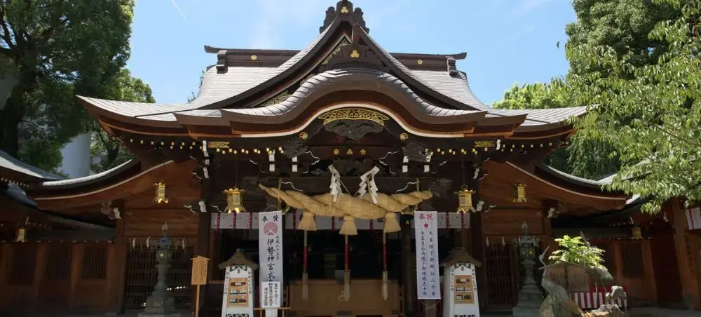 Traditional Shinto shrine with curved rooflines and sacred ropes in Fukuoka, showcasing Japan's spiritual heritage