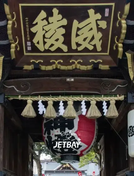 Traditional Japanese shrine entrance with ornate wooden architecture and ceremonial decorations in Fukuoka