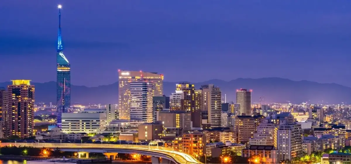 Fukuoka city skyline illuminated at twilight with modern skyscrapers and Fukuoka Tower glowing blue