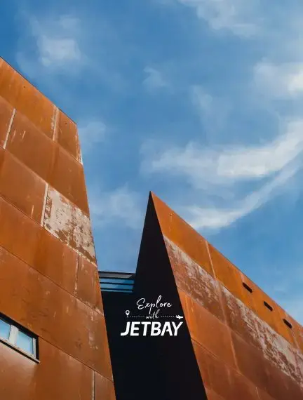 Modern rust-colored architecture with Jetbay branding against blue sky in Gdansk, Poland