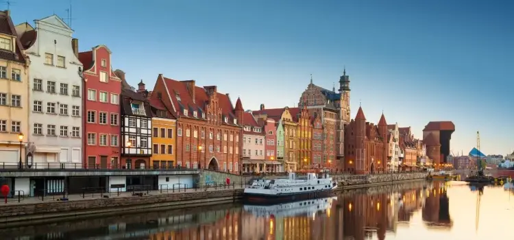 Historic colorful buildings and medieval architecture reflected in Gdansk waterfront at golden hour