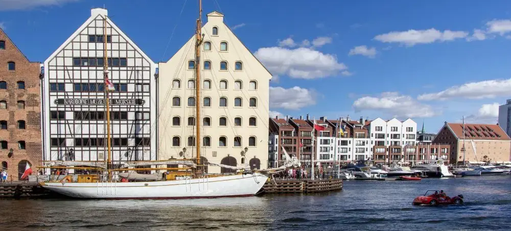 Historic Gdansk waterfront with colorful merchant buildings and sailing vessels in Poland's Baltic port city