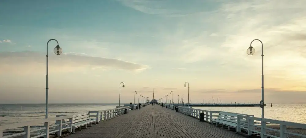 Wooden pier extending into Baltic Sea at sunset in Gdansk, showcasing Poland's coastal charm