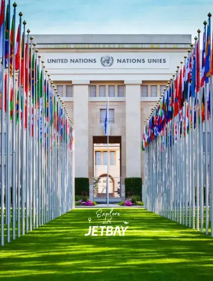 United Nations headquarters in Geneva with colorful international flags lining the ceremonial pathway