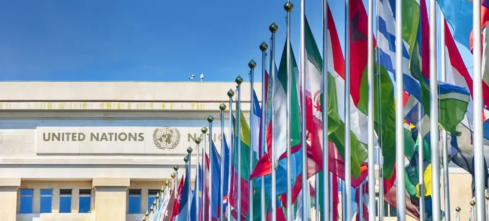 United Nations headquarters in Geneva with colorful international flags representing global diplomacy