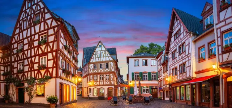 Historic German town square with traditional half-timbered buildings illuminated at twilight