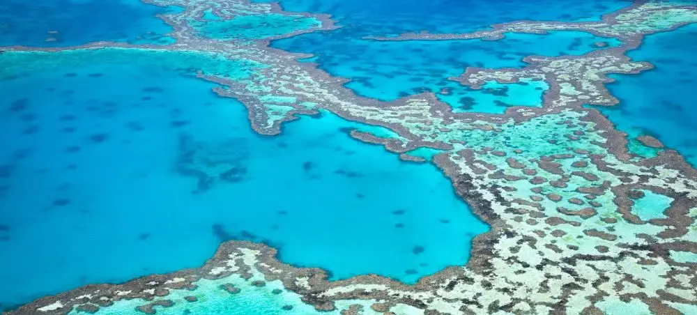 Aerial view of Great Barrier Reef coral formations in brilliant turquoise waters off Australia's coast