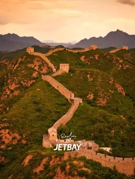 Great Wall of China winding through green mountains at golden sunset, showcasing Beijing's iconic landmark