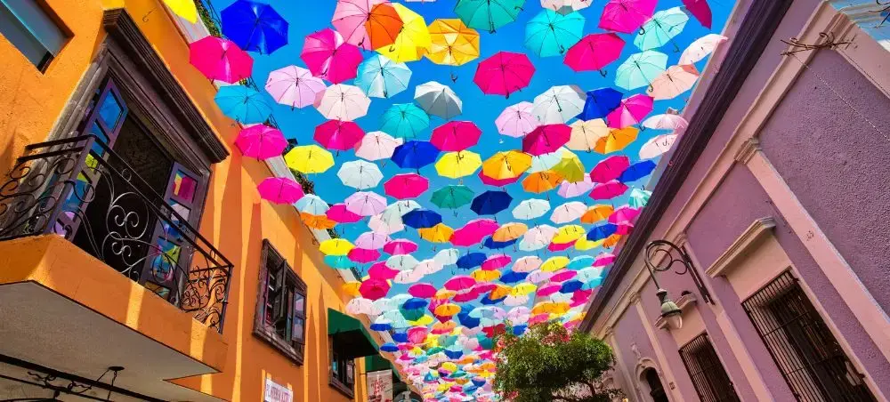 Colorful umbrella installation suspended above historic street in Guadalajara's vibrant downtown district