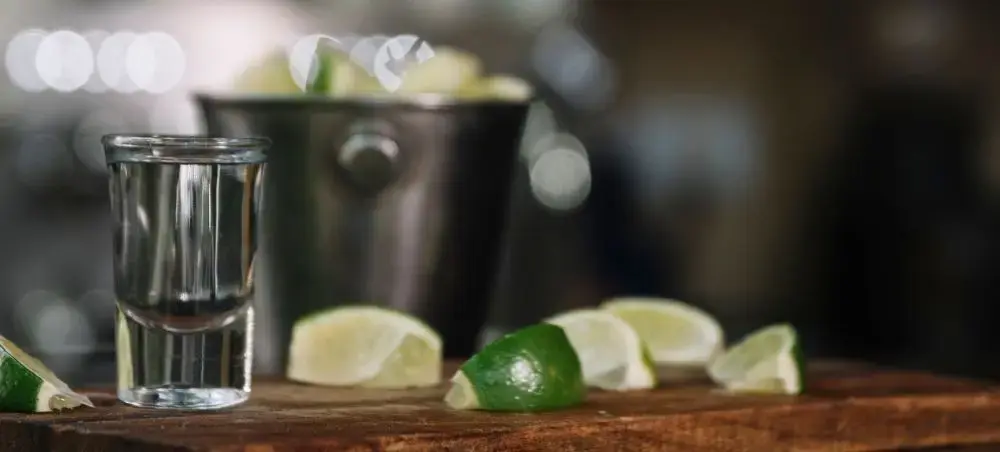 Premium tequila shot glass with fresh lime wedges and ice bucket for luxury Guadalajara travel experience