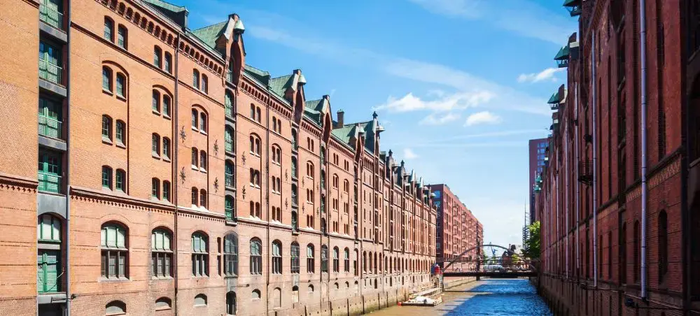 Historic red brick warehouses line a scenic canal in Hamburg's UNESCO World Heritage Speicherstadt district