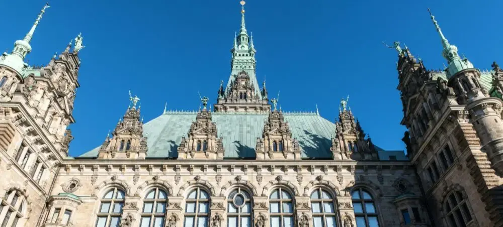 Hamburg Town Hall's ornate Neo-Renaissance architecture with copper spires against brilliant blue sky