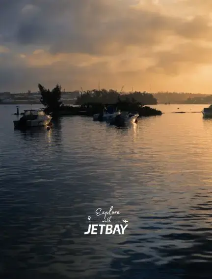 Tranquil Hamilton Harbor at golden hour with luxury boats moored near lush Bermuda coastline