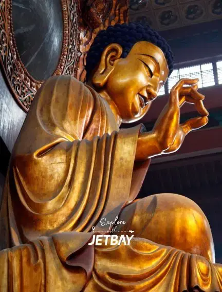 Golden Buddha statue in ornate temple interior showcasing Hangzhou's spiritual heritage and cultural attractions