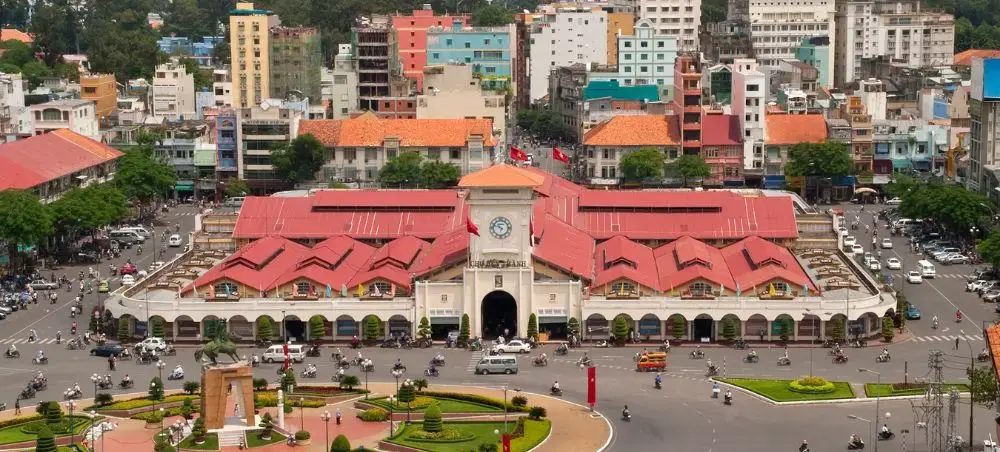 Historic Ben Thanh Market with distinctive red roof architecture in bustling Ho Chi Minh City center