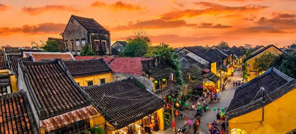 Historic Hoi An Ancient Town at sunset with traditional yellow buildings and bustling street scene near Da Nang