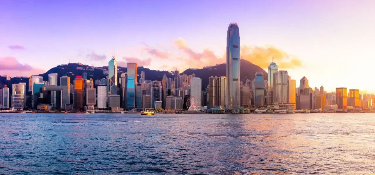 Hong Kong skyline at sunset showcasing towering skyscrapers and Victoria Harbour waters
