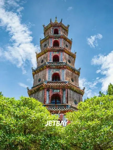 Historic Thien Mu Pagoda's seven-story octagonal tower rising above lush gardens in Hue, Vietnam