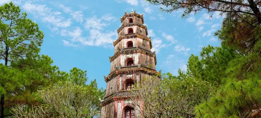 Historic Thien Mu Pagoda tower rising above lush gardens in Hue, Vietnam's former imperial capital