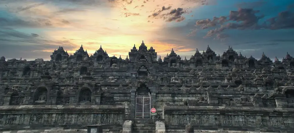 Ancient Borobudur temple complex in Indonesia showcasing intricate stone architecture at golden sunset