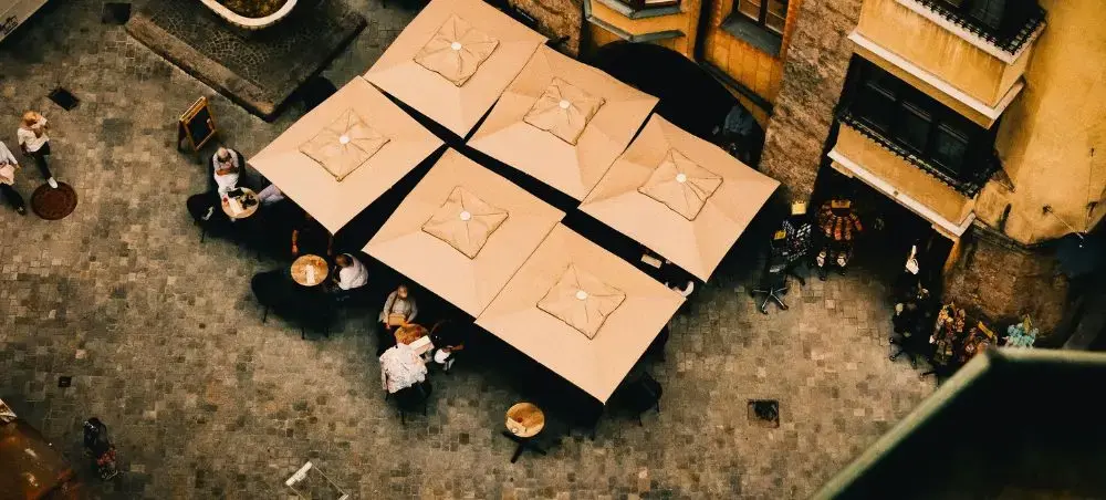 Aerial view of elegant outdoor dining terrace with umbrellas in historic Innsbruck city center