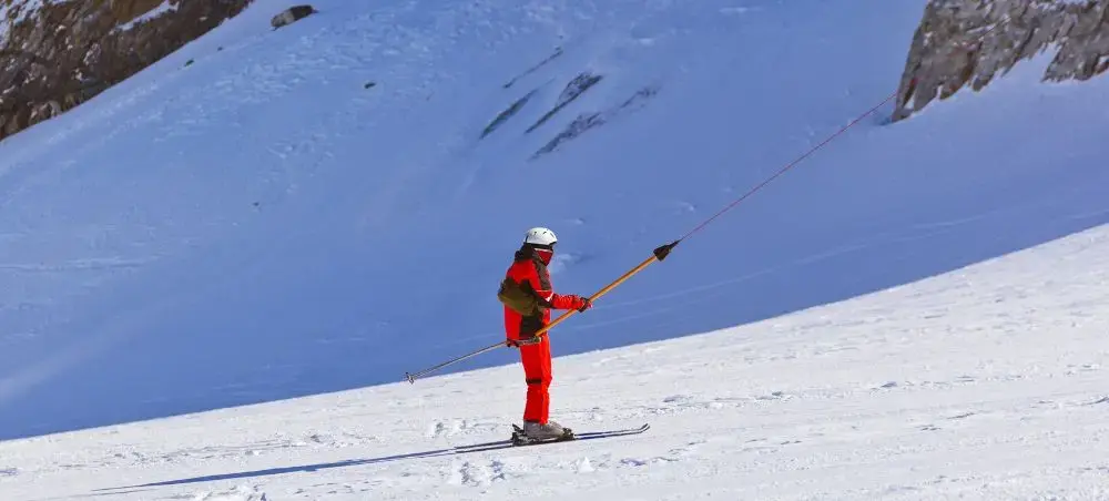 Professional ski instructor in red gear teaching on pristine alpine slopes near Innsbruck, Austria