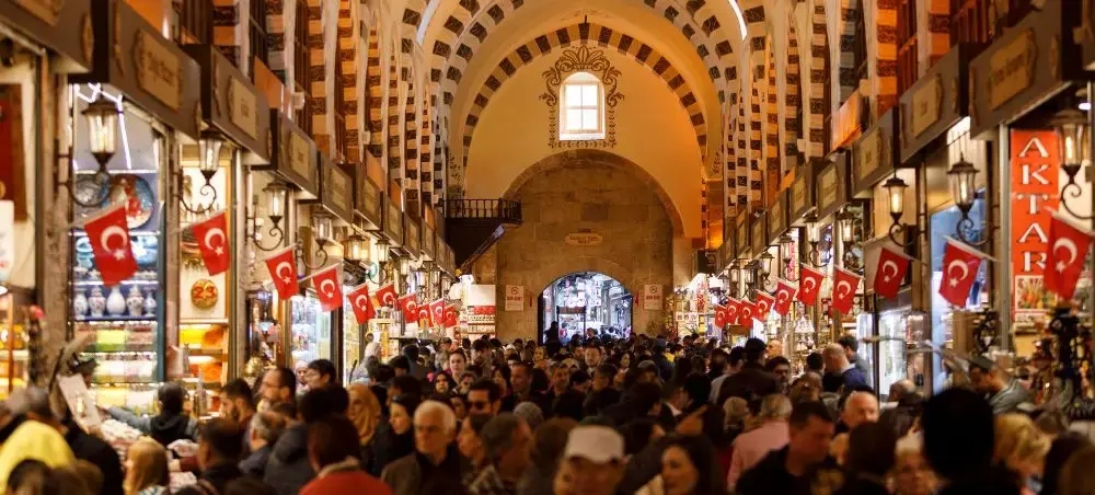 Bustling Grand Bazaar in Istanbul with traditional Ottoman architecture and crowds exploring Turkish shops