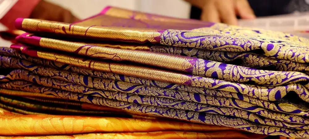 Exquisite purple and gold silk fabrics with intricate traditional patterns at Jaipur textile market