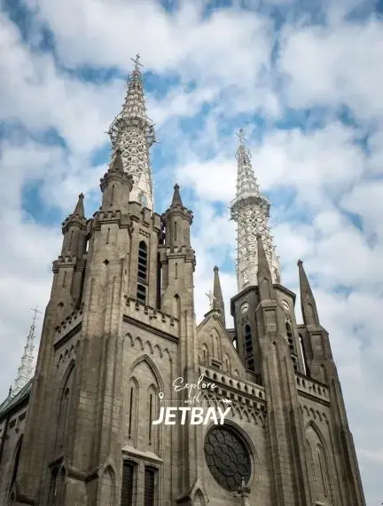 Gothic cathedral spires reaching toward cloudy sky in Jakarta, showcasing Indonesia's colonial architectural heritage