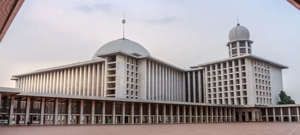 Istiqlal Mosque's modern white architecture with twin domes and minarets in Jakarta, Indonesia