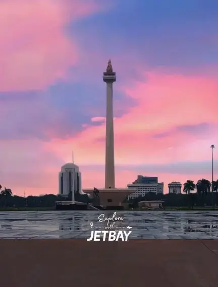 Jakarta's iconic Monas tower stands tall against vibrant sunset skies in Indonesia's bustling capital city