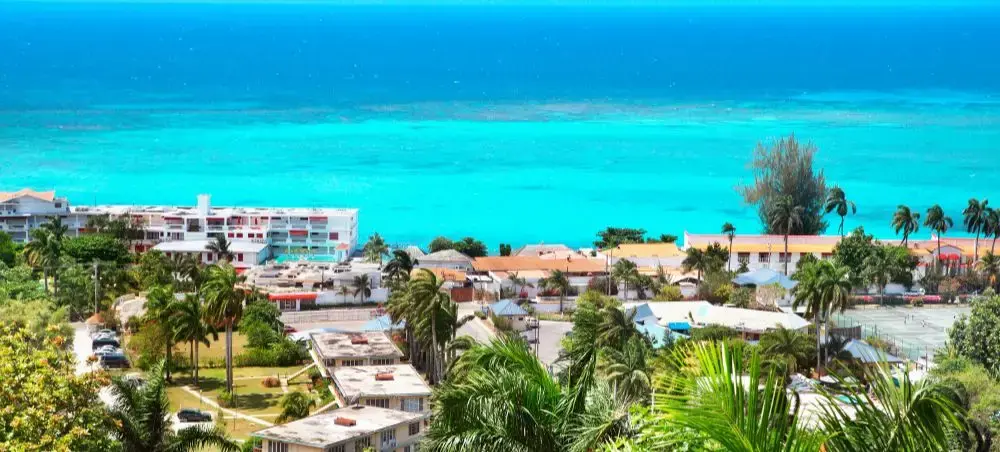 Tropical Caribbean coastline with turquoise waters, palm trees, and luxury resorts in Jamaica