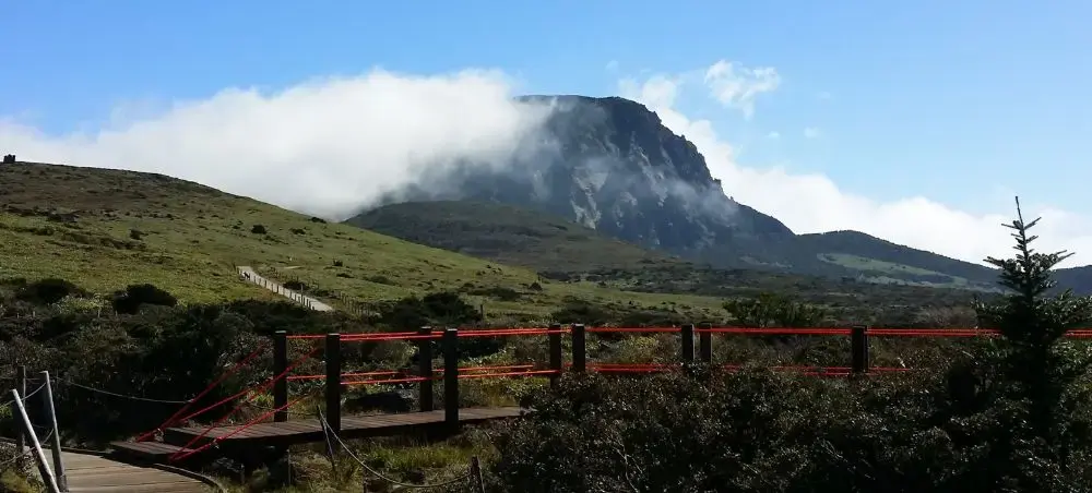 Hallasan mountain peak shrouded in clouds viewed from hiking trail on Jeju Island, South Korea