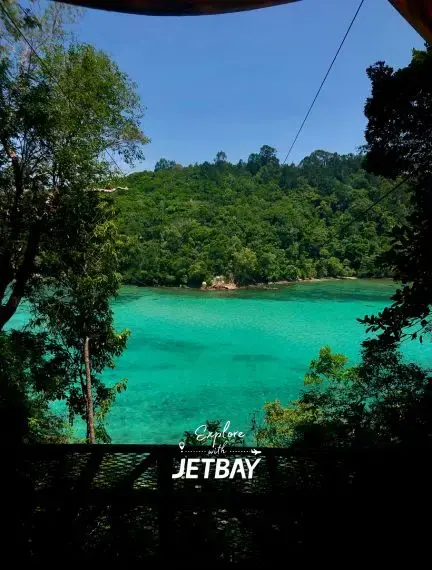 Pristine turquoise lagoon surrounded by lush tropical rainforest in Kota Kinabalu, Malaysia