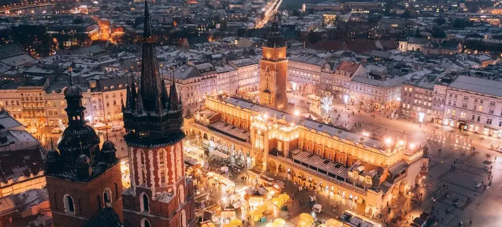 Krakow's illuminated Main Market Square at dusk showcasing historic architecture and vibrant nightlife
