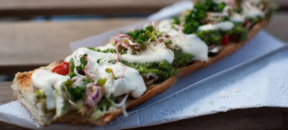 Gourmet Polish open-faced sandwich with fresh herbs and cream sauce showcasing Krakow's culinary scene