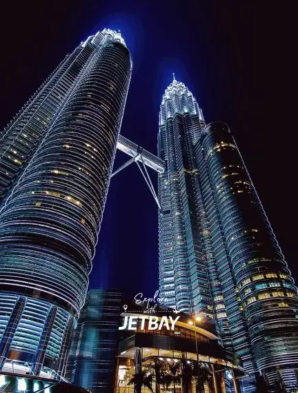 Jetbay branding illuminated beneath iconic Petronas Twin Towers in Kuala Lumpur's glittering skyline at night