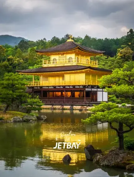 Golden Pavilion temple reflecting in tranquil pond waters surrounded by lush gardens in Kyoto, Japan