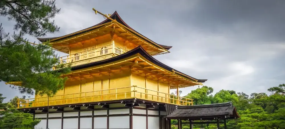 Golden Pavilion temple in Kyoto showcasing traditional Japanese architecture amid lush gardens