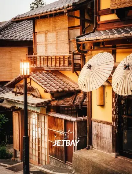 Traditional wooden machiya townhouses with paper umbrellas in historic Kyoto district for luxury travel